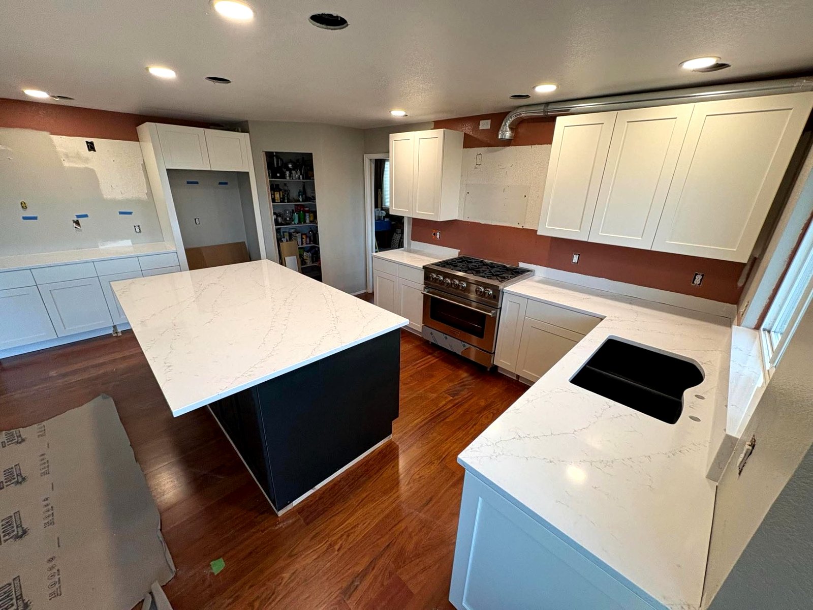 Quartz Waterfall Island — Full kitchen remodel with a veined quartz island and perimeter tops